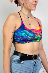 Freedom Rave Wear crop top with a vibrant dinosaur sunset print, paired with high-waisted denim shorts and a black belt, ideal for rave festivals.