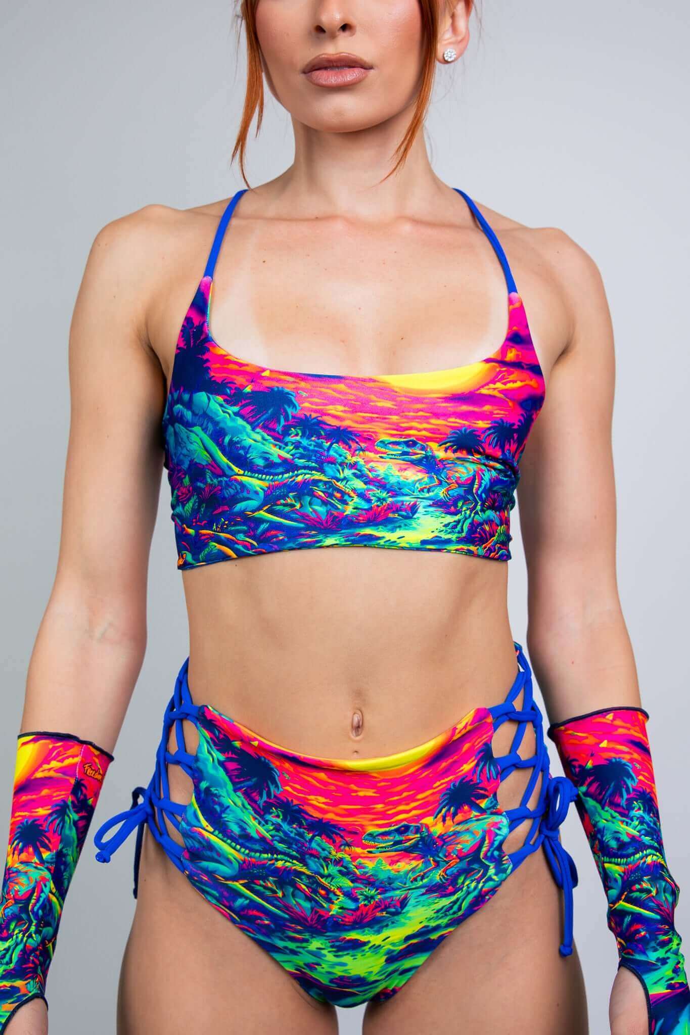 Freedom Rave Wear vibrant two-piece set with neon dinosaur sunset print. Includes a bralette top and high-waisted lace-up shorts for rave style.