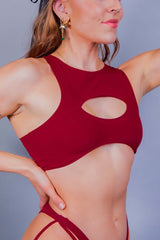 Stylish close-up of a model in Freedom Rave Wear's red cut-out teaser top, accentuating a contemporary rave look.
