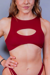 Close-up of a woman in a red cut-out teaser top from Freedom Rave Wear, showcasing a sleek and modern design.