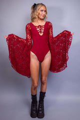 Full-length view of a model in a red lace-sleeved rave bodysuit by Freedom Rave Wear, paired with combat boots.
