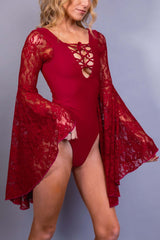 Full-length view of a model in a red lace-sleeved rave bodysuit by Freedom Rave Wear, paired with combat boots."