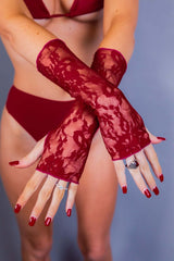 Detailed shot of a woman's hands in red lace gloves from Freedom Rave Wear, showcasing stylish rave accessories.