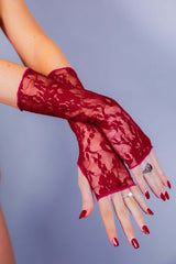 Elegant close-up of a woman's hand wearing a red lace glove from Freedom Rave Wear, complemented by a chic ring.