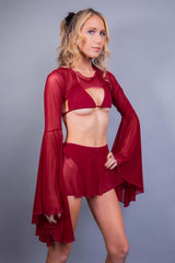 Model showcases rave outfit from Freedom Rave Wear, featuring scarlet mesh bell sleeves and swirling skirt.