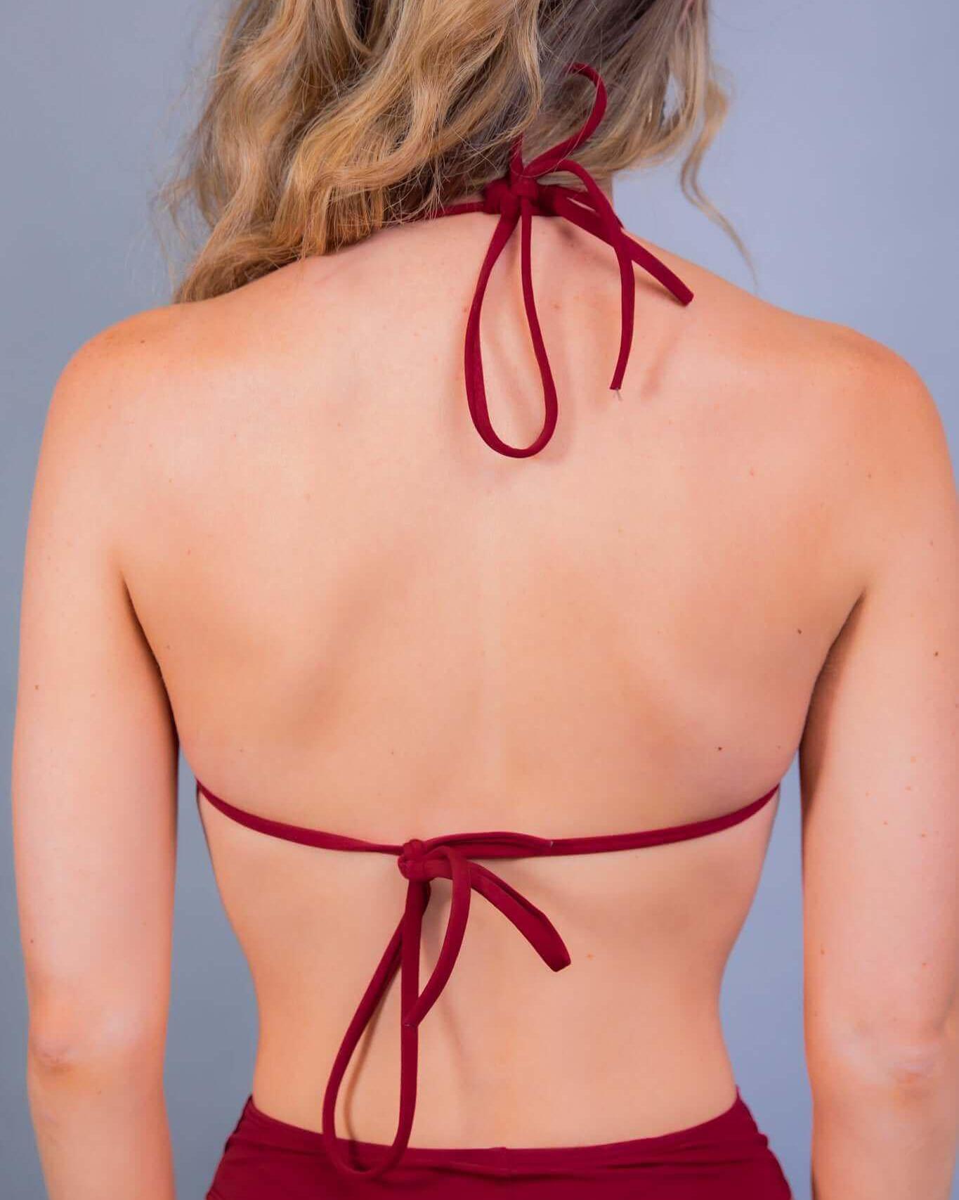 Back view of a woman wearing a scarlet strappy bikini top, perfect for rave outfits and summer adventures.