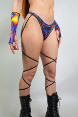 High hip strappy rave bottoms with blue and orange dragon print, featuring stylish strappy details and bold accessories.