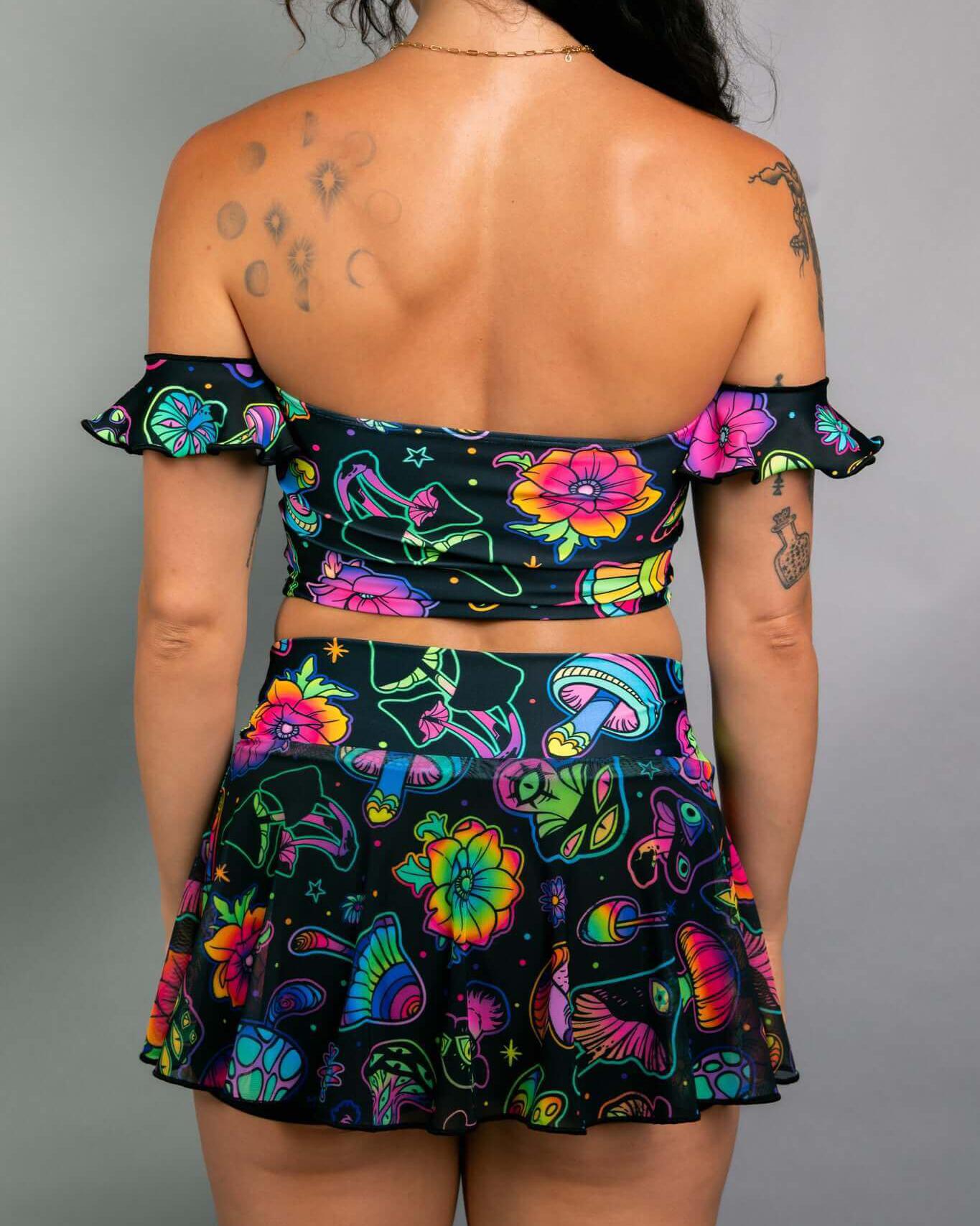 Woman wearing a colorful off-the-shoulder Bardot top and matching skirt, showcasing a playful rave outfit design.