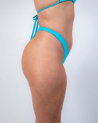Siren Risk Bikini Bottoms in vibrant blue, showcasing a high-cut, cheeky silhouette perfect for rave outfits.