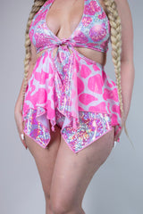 Model wearing a sparkly pink cow print bikini set with a flowy overlay, perfect for rave outfits and summer fun.