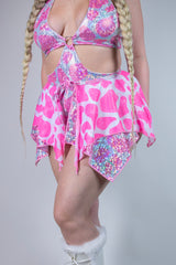 Model showcasing a pink sparkly cow print outfit, perfect for rave outfits, featuring a flared mini skirt.