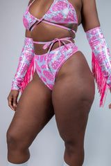 Model wearing a sparkly pink cow print bikini and high-waisted thong, showcasing rave outfits style.