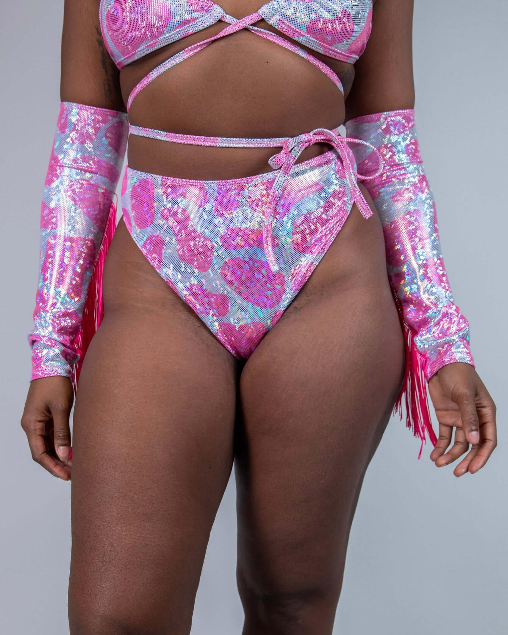 Model in sparkly pink cow print high-waisted thong and matching top, perfect for rave outfits and summer festivities.