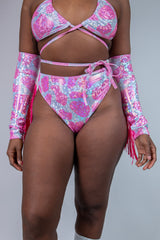 Model in sparkly pink cow print high-waisted thong and matching top, perfect for rave outfits and summer festivities.