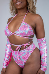 Model in a sparkly pink wrap bikini top and matching high-waisted bottoms, perfect for rave outfits and summer fun.