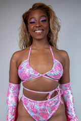 Model showcasing the Strawberry Milkshake Wrap Bikini Top with pink cow print and sparkle, perfect for rave outfits.