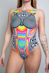 Model wearing a Technicolor Extra Coverage Sideboob Bodysuit, front view featuring vibrant multicolor geometric patterns and high neck design, ideal for rave wear.