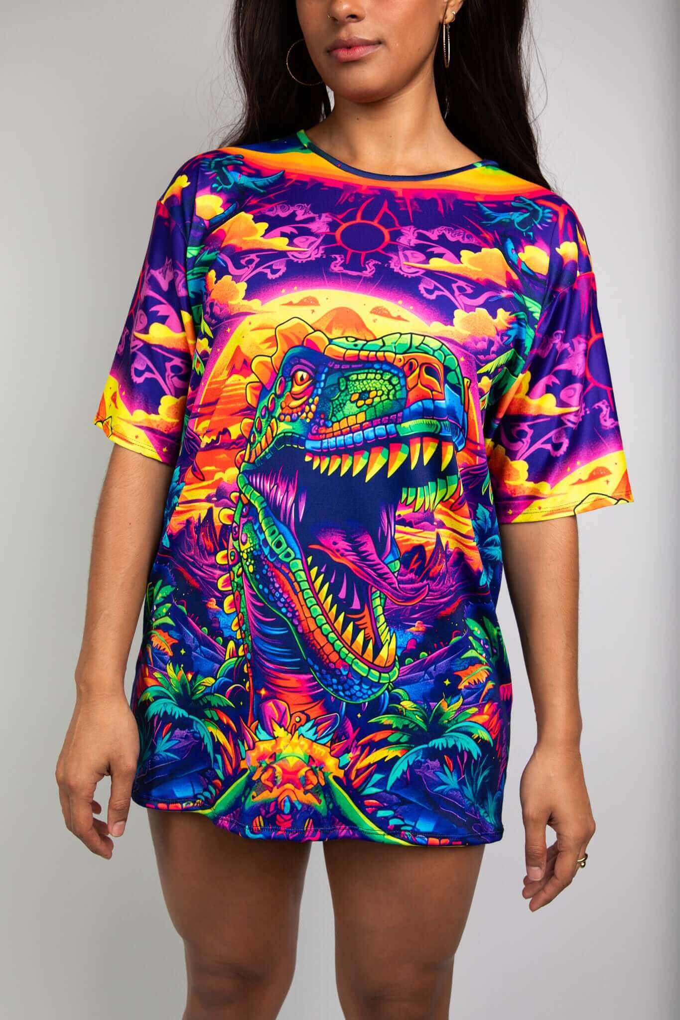 Model in Freedom Rave Wear t-shirt with vibrant dinosaur graphic, showcasing a roaring T-Rex in colorful, psychedelic design.