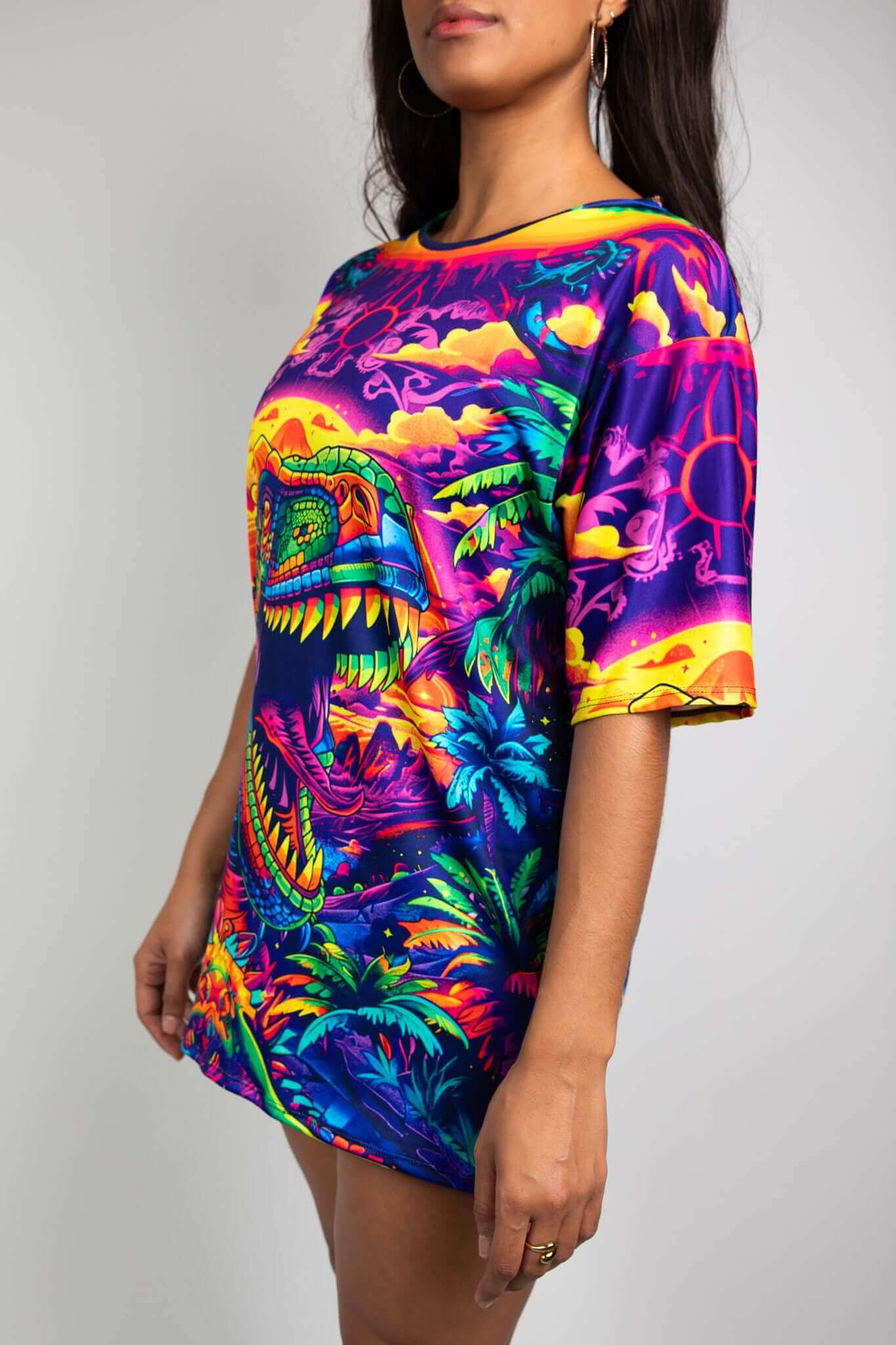 Side angle of a model wearing a Freedom Rave Wear t-shirt with neon dinosaur graphics, highlighting rave fashion aesthetics.