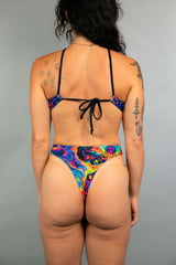 Back view of Freedom Rave Wear's swirl bodysuit featuring a tie-back top and high-cut bottom, highlighting the vibrant, psychedelic print.