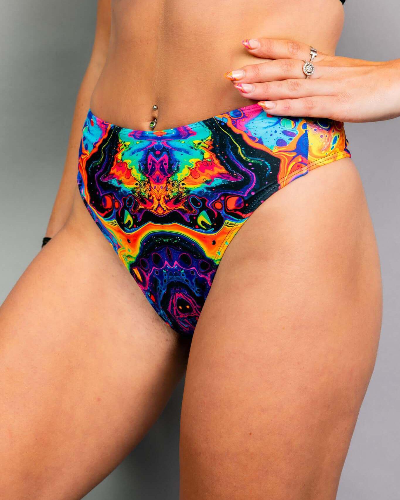 Vivid high waisted thong featuring a trippy rainbow design, perfect for rave outfits and made from recycled materials.