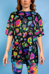 Psychedelic oversized tee from Freedom Rave Wear featuring colorful mushrooms, flowers, and abstract designs. Perfect for rave vibes.