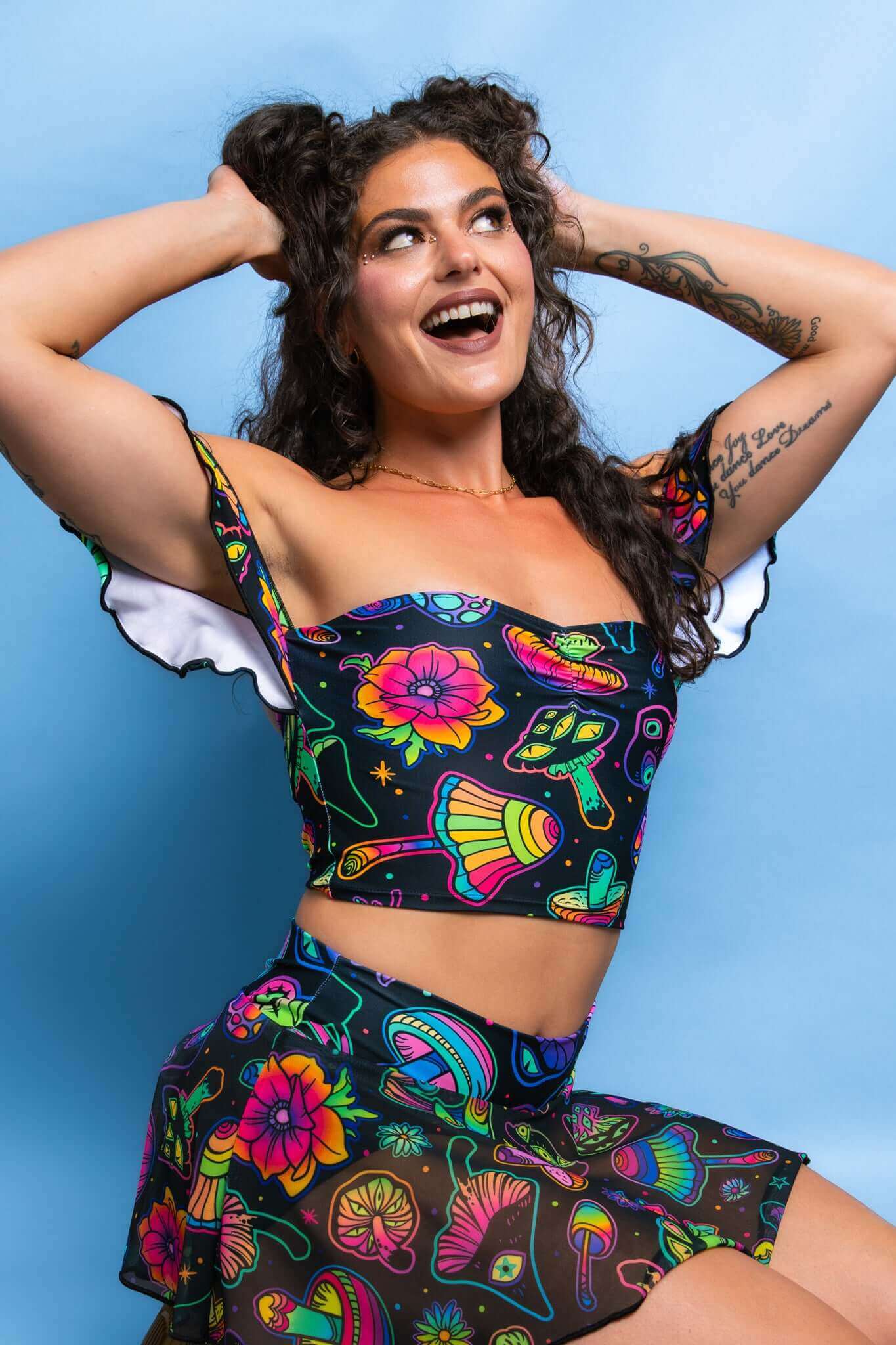 Freedom Rave Wear’s vibrant two-piece set features a playful, psychedelic print with colorful mushrooms and flowers, flared sleeves, and a matching skirt. 