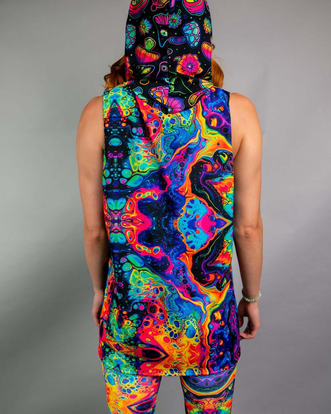 Model wearing Vivid Shroomie unisex hooded tank top, featuring a colorful psychedelic design, perfect for rave outfits.