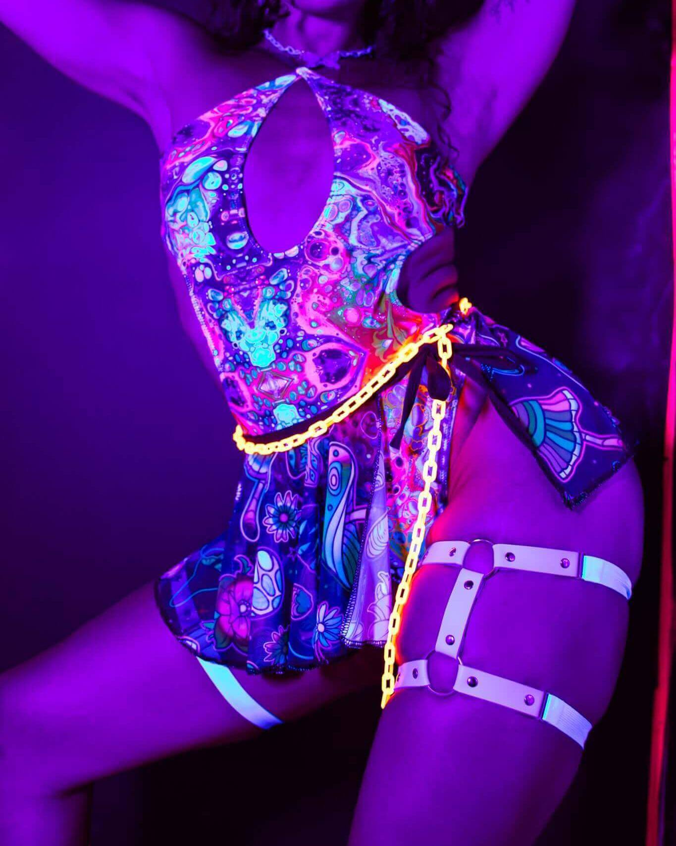 Vibrant model in Vivid Halo Bodysuit with keyhole cutout, glowing under neon lights, perfect for rave outfits.