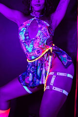 Vibrant model in Vivid Halo Bodysuit with keyhole cutout, glowing under neon lights, perfect for rave outfits.