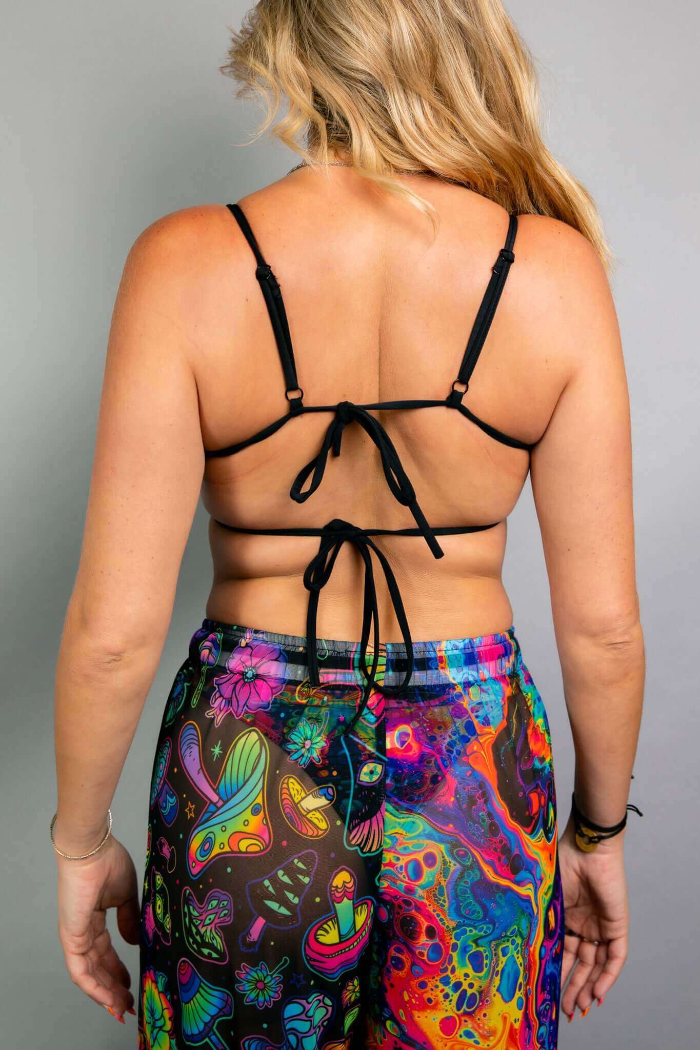 Model showing the back of a Freedom Rave Wear top with adjustable ties and matching psychedelic pants. Ideal for bold and vibrant rave outfits.