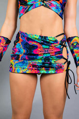 Vivid Verano Mini Skirt with rainbow trippy print and lace-up design, perfect for rave outfits.