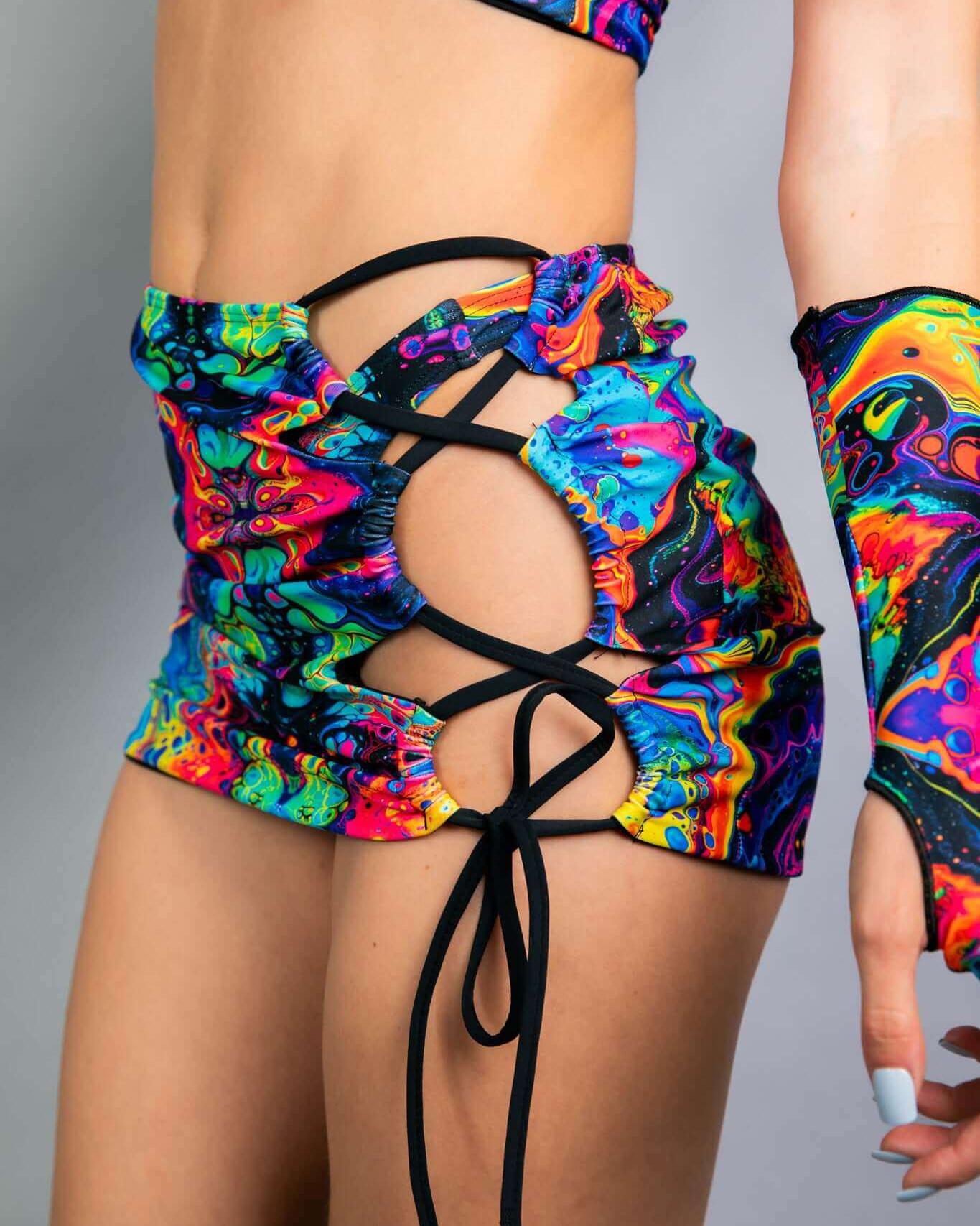 Vivid Verano Mini Skirt with vibrant rainbow trippy print and lace-up design, perfect for rave outfits.