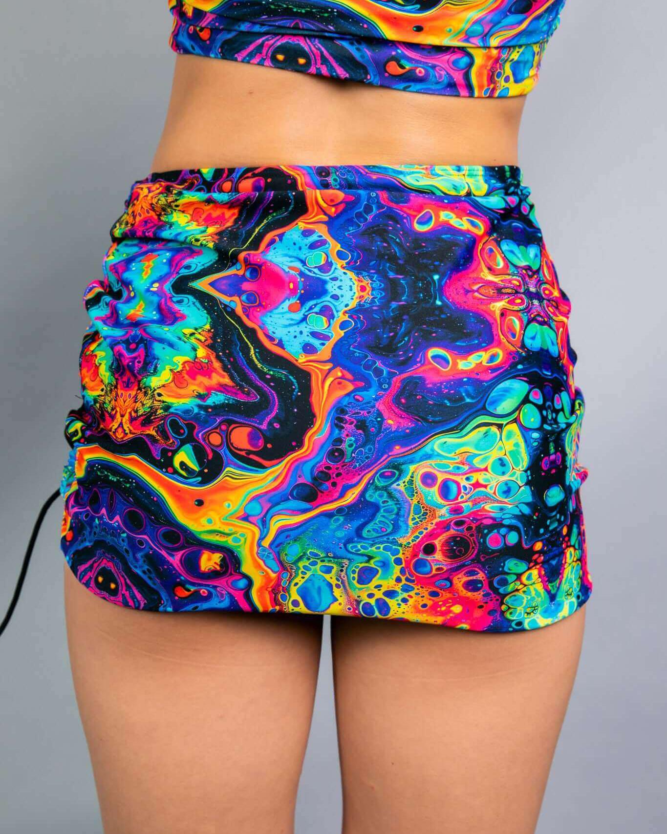 Vibrant rainbow trippy print mini skirt, perfect for rave outfits and stylish nighttime adventures.