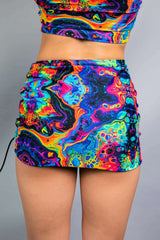 Model wearing a Freedom Rave Wear skirt featuring a vibrant, psychedelic neon pattern. Perfect for rave fashion and festival style enthusiasts.