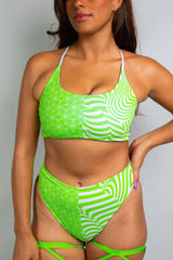 Close-up of a woman in a Freedom Rave Wear outfit with green and white psychedelic patterns, featuring a high-waisted design.