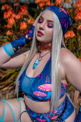 Model wearing Wildwood Bandana in an outdoor setting, paired with a matching rave outfit featuring an Alice in Wonderland-inspired print.