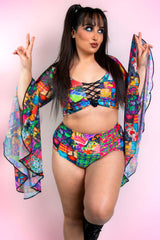A woman wearing rainbow patchwork bikini bottoms and a matching crop top with flowy sleeves.