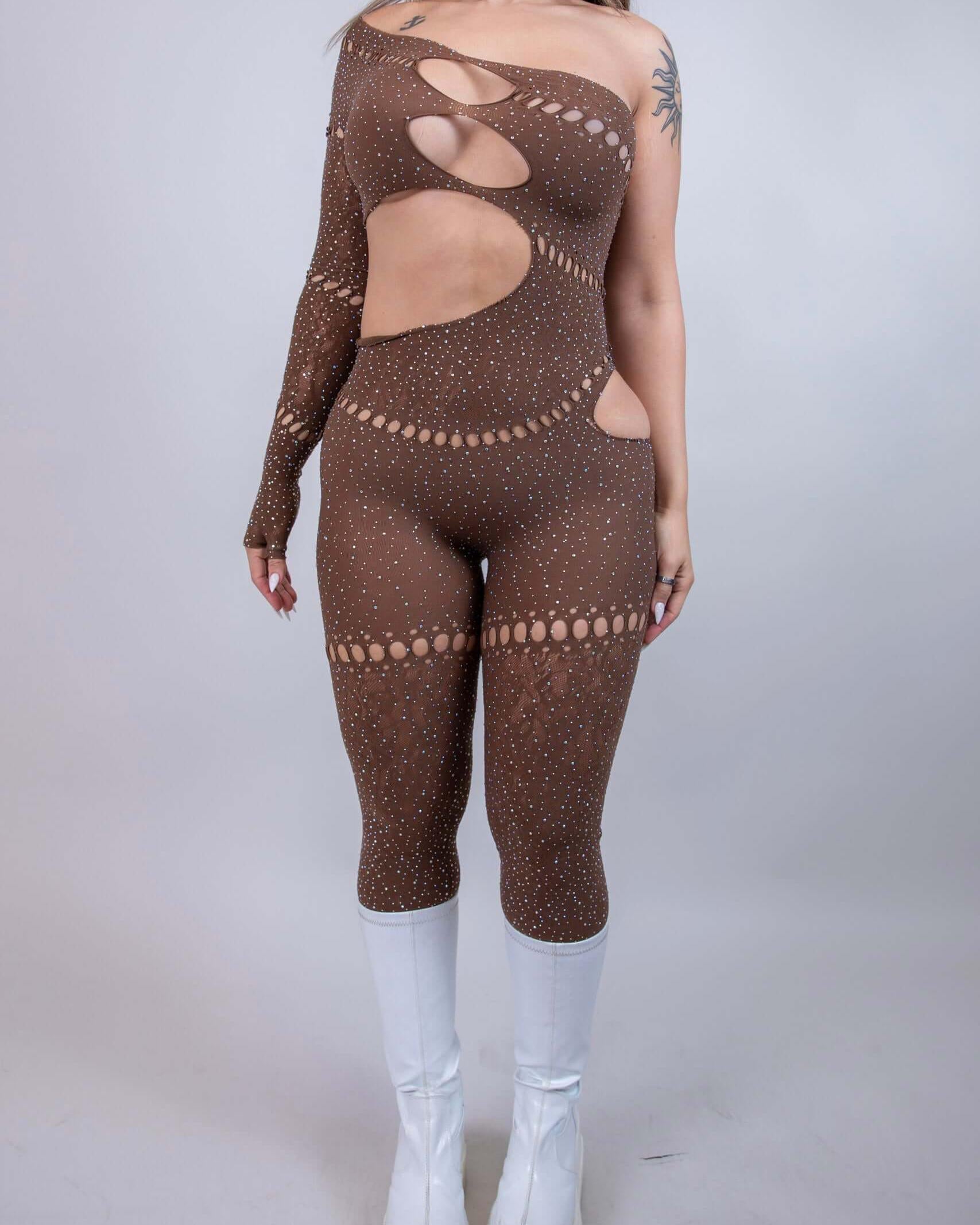 Model wearing The Zoe Asymmetrical Rhinestone Jumpsuit in brown with cutouts and rhinestones, styled for rave outfits.