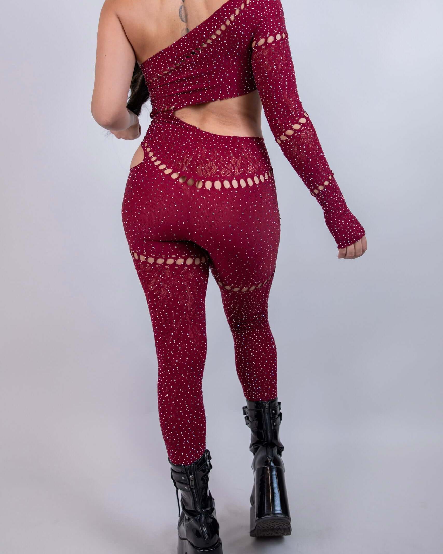 Back view of The Zoe Asymmetrical Rhinestone Jumpsuit in burgundy, featuring cutouts and rhinestone details, perfect for rave outfits.