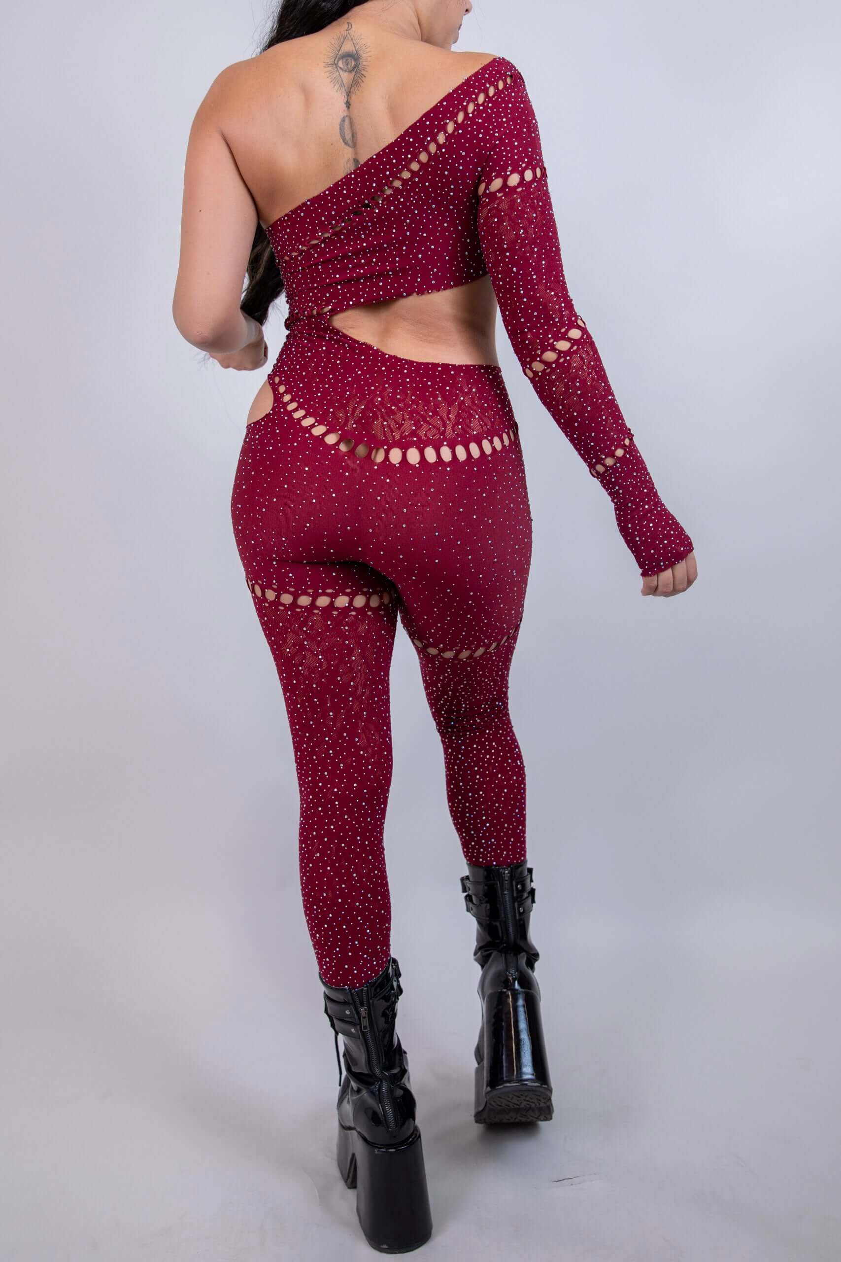 Back view of The Zoe Asymmetrical Rhinestone Jumpsuit in burgundy, featuring cutouts and rhinestone details, perfect for rave outfits.