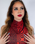 Model showcasing a vibrant red and black patterned outfit, perfect for festival rave outfits with glam makeup.