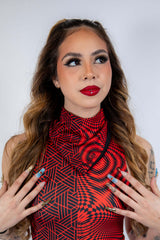 Model showcasing a vibrant red and black patterned outfit, perfect for festival rave outfits with glam makeup.