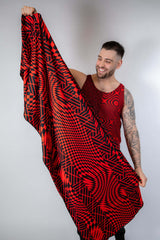 Man showcasing the Amplitude Festival Scarf with red and black geometric patterns, perfect for rave outfits.
