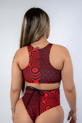 Model wearing Amplitude Teaser Top with strappy back, showcasing a trendy red abstract rave outfit.