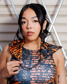 Woman wearing Atomic Assassin Hood in orange and black, featuring a dystopian design perfect for post-apocalyptic and rave themes.