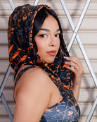Model wearing Atomic Assassin Hood in orange and black, showcasing a post-apocalyptic, dystopian style with a warrior vibe.