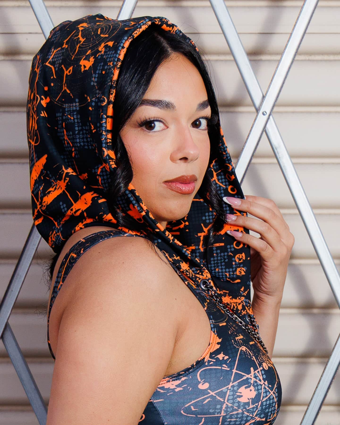 Model wearing Atomic Assassin Hood in orange and black, showcasing a post-apocalyptic, dystopian style with a warrior vibe.