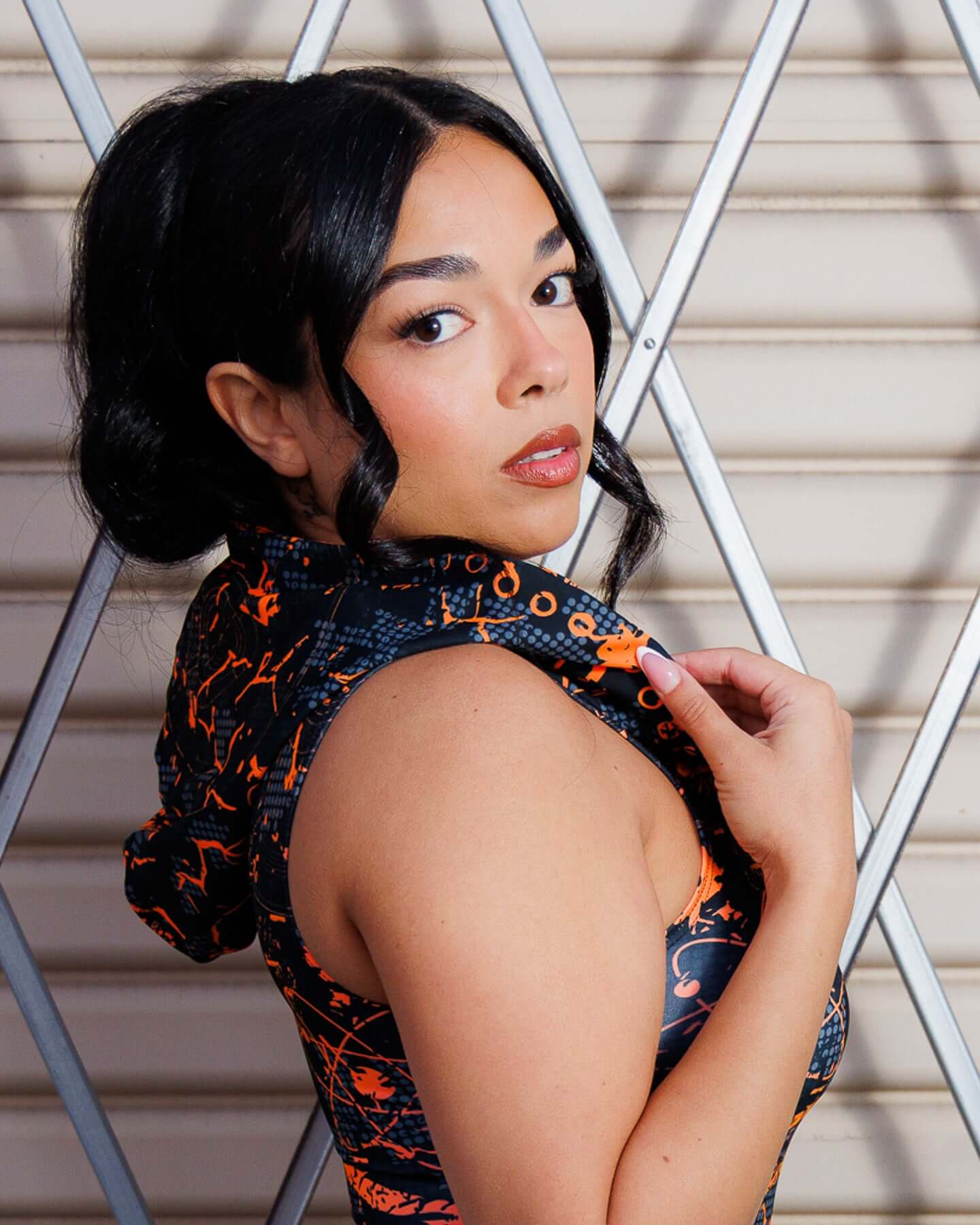 Model wearing Atomic Assassin Hood in orange and black design.