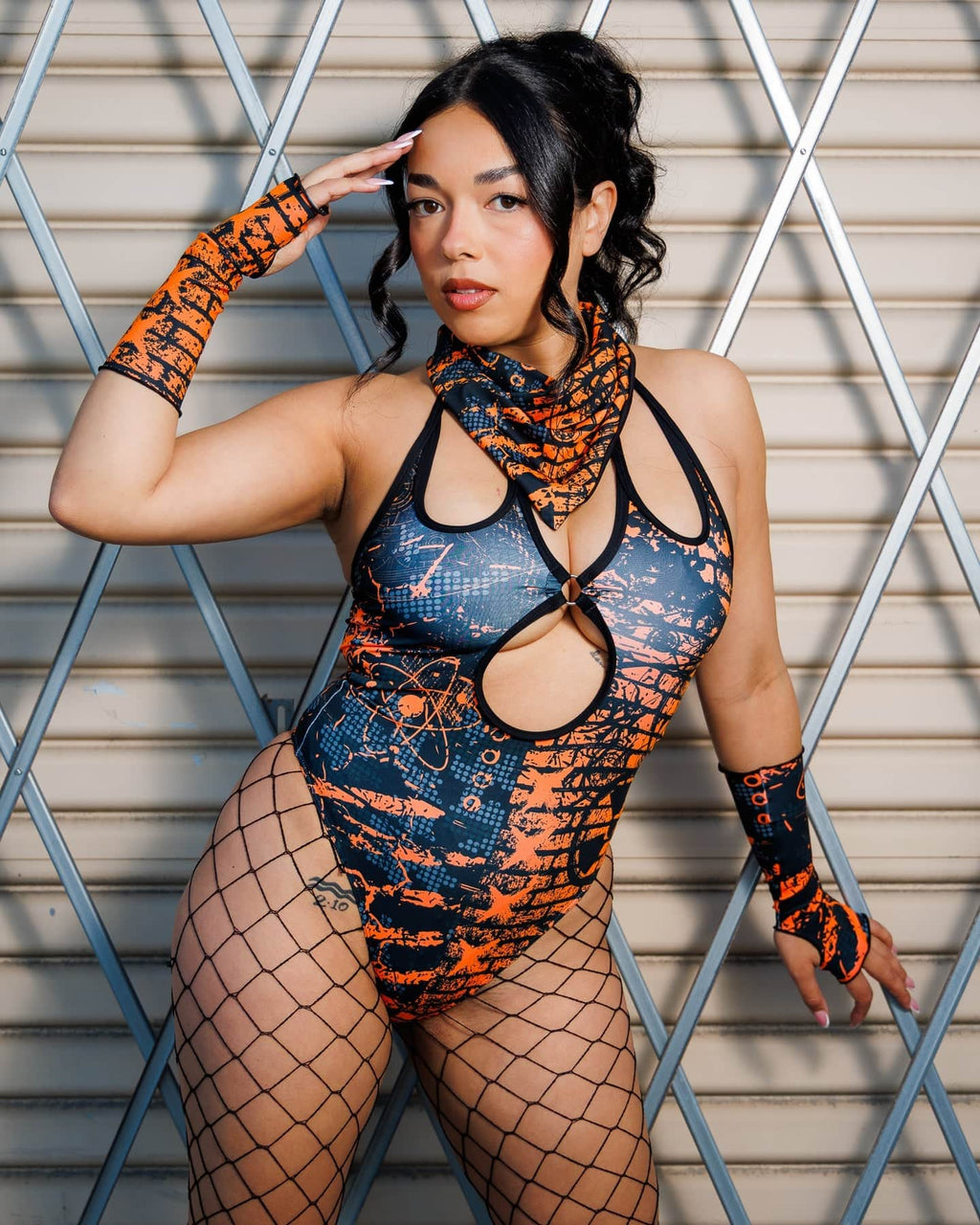 Model wearing the Atomic Bandana in orange and black tones as a face cover, styled with a matching post-apocalyptic outfit.